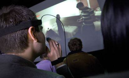 Un hombre, ve la película conectado a sensores que envían respeustas a un ordenador.