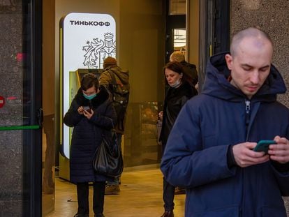 Un hombre y una mujer usaban sus móviles en Moscú, en marzo de 2022.