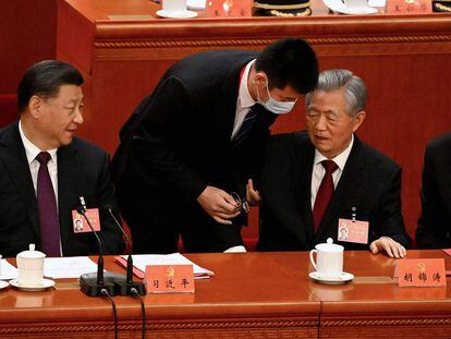 El presidente de China, Xi Jinping, a la izquierda, miraba al antiguo presidente Hu Jintao, cuando era escoltado para abandonar la ceremonia de clausura del XX Congreso del Partido Comunista, este sábado en Pekín.