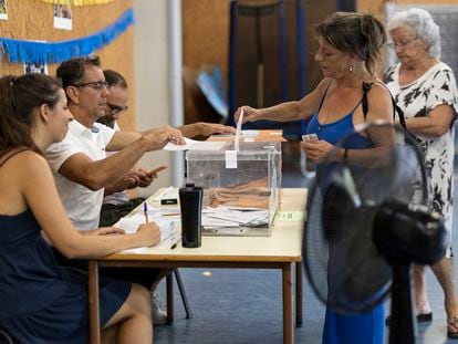 Una mujer vota en un colegio electoral de Barcelona equipado con múltiples ventiladores, este domingo.