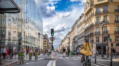 Varias personas circulan en bicicleta por el amplio carril bici de la calle Rivoli, en el centro de París.