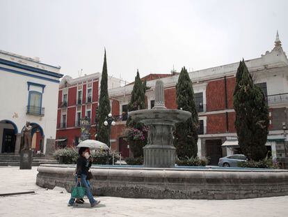 Dos personas se protegen de la lluvia de ceniza en Puebla.