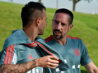 Ribery (D) habla con Rafinha en el entrenamiento de este domingo.  