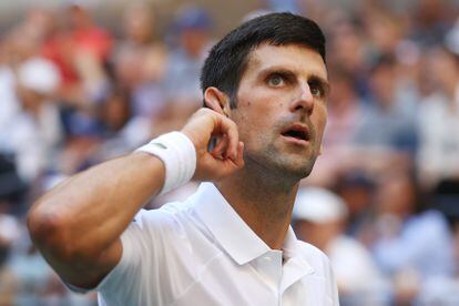 Novak Djokovic se lleva la mano a la oreja durante el partido contra Nishikori en la tercera ronda.