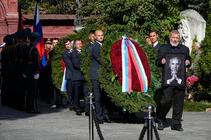 El premio Nobel de la Paz Dmitri Muratov (a la derecha) sostiene una imagen del estadista durante el funeral en el cementerio Novodévichy de Moscú.