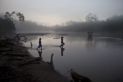 Dos niñas bajan a recoger agua en la orilla del río Purus en Ucayali, Perú.
