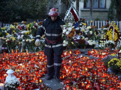 Un bombero deposita flores en la entrada del club incendiado en Bucarest, el domingo.