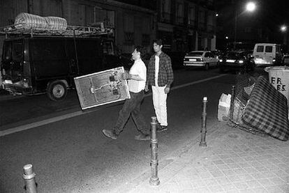 Dos hombres recogen muebles en la zona de Argüelles, en 1996.