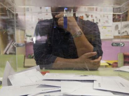 Un miembro de una mesa electoral electoral tras una urna en las pasadas elecciones europeas en un colegio de Madrid