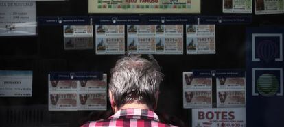 Una mujer frente a la ventanilla de una administración de lotería.