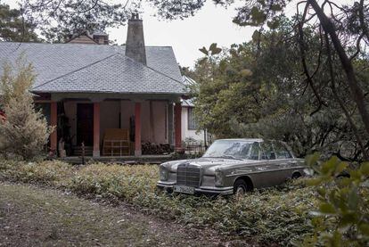 Una casa de Camorritos, con un Mercedes antiguo en el jardín. 