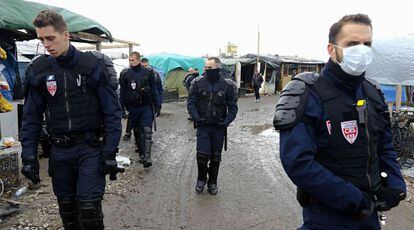 Un grupo de antidisturbios (CRS) de la policía francesa patrulla por el campamento de refugiados de Calais.