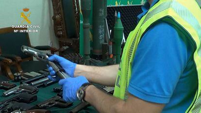 Un agente con algunas de las armas localizadas en una vivienda de Zaragoza.