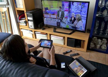 Ver la televisión y enviar mensajes con la tableta o el móvil es un hábito en los hogares.