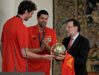 Gasol, a la izquierda, regala al presidente del Gobierno, Mariano Rajoy, un bal&oacute;n de plata en La Moncloa tras la victoria en el Eurobasket.