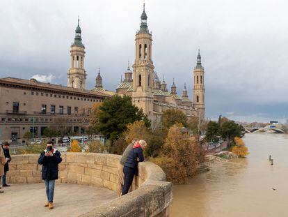 Varios turistas observan el río Ebro a su paso por Zaragoza este martes.
