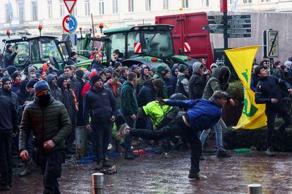 Agricultores y ganaderos lanzan objetos a la policía en el exterior de la sede de la UE, este jueves en Bruselas. 