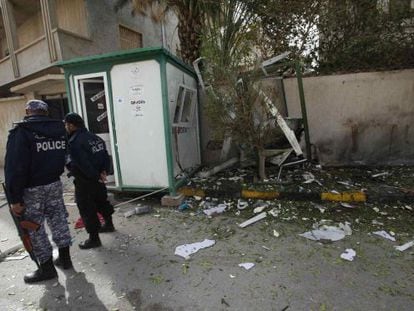 Dos polic&iacute;as junto al lugar donde explotaron los artefactos en la puerta de la residencia del embajador iran&iacute; en Tr&iacute;poli. 