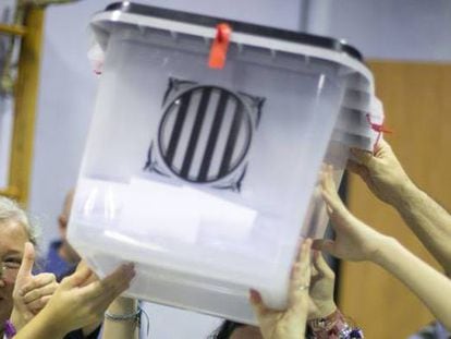 Un grupo de personas sostiene una urna en un colegio de Barcelona durante el referéndum del 1 de octubre de 2017.