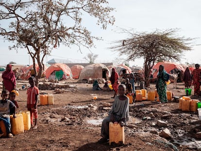 La gente espera a coger agua con contenedores en un campamento para desplazados en Baidoa (Somalia), en febrero de 2022.