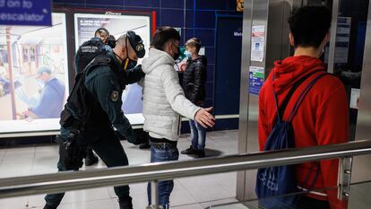 Un agente de la Guardia Civil cachea a un joven en un control para prevenir la violencia entre bandas juveniles, en la estación de metro de Arganda del Rey (Madrid).
