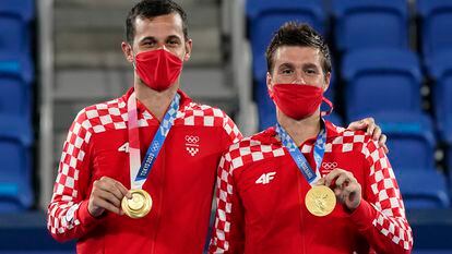 Mate Pavic, left, and Nikola Mektic, of Croatia, pose with their gold medals during a medals ceremony for the men's doubles tennis competition at the 2020 Summer Olympics, Friday, July 30, 2021, in Tokyo, Japan. (AP Photo/Patrick Semansky)