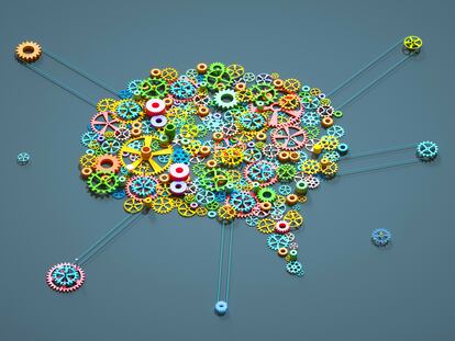 Digital generated image of multi coloured gear wheels connected together in shape of brain on grey background.