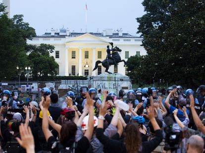 Washington (United States), 22/06/2020.- Protesters put their hands in the air as police clear out Lafayette Park across the street from the White House after protesters attempted to pull down the Andrew Jackson statue in the park, in Washington DC, USA, 22 June 2020. Police used chemical agents to clear out Lafayette Park and skirmishes broke out between protesters and police. The death of George Floyd in the Minneapolis police custody on 25 May 2020 has sparked global protests demanding justice and racial equality. (Protestas, Estados Unidos) EFE/EPA/MICHAEL REYNOLDS