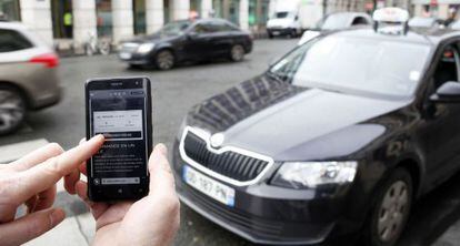Un usuari utilitza el m&ograve;bil per reservar un cotxe d&#039;Uber. 