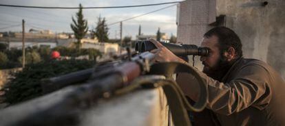 Un opositor a El Asad observa los combates en la provincia de Idlib.