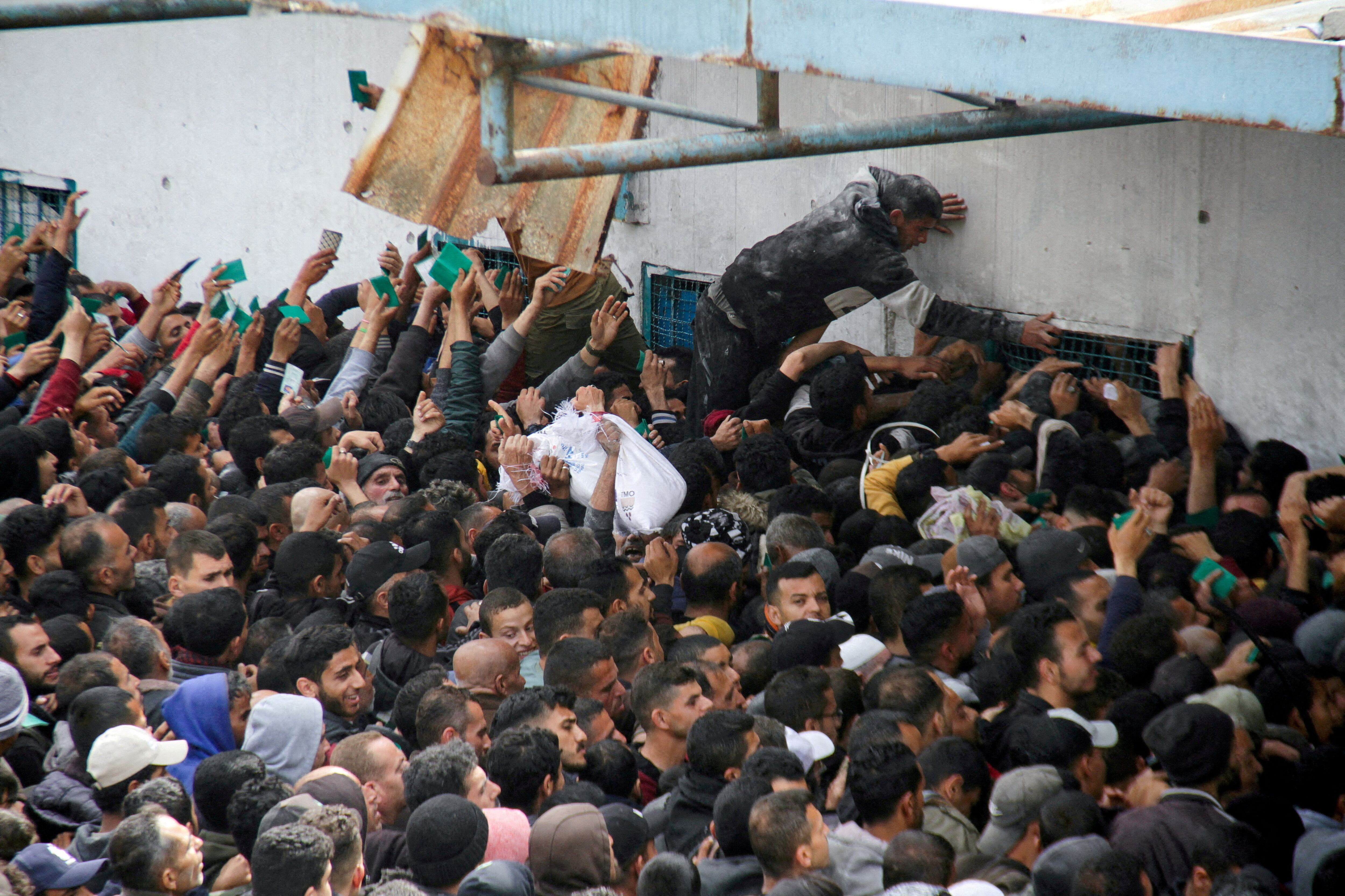 Palestinos se agolpan ante un almacén de la UNRWA en la ciudad de Gaza a la espera de recibir ayuda, el 18 de marzo.