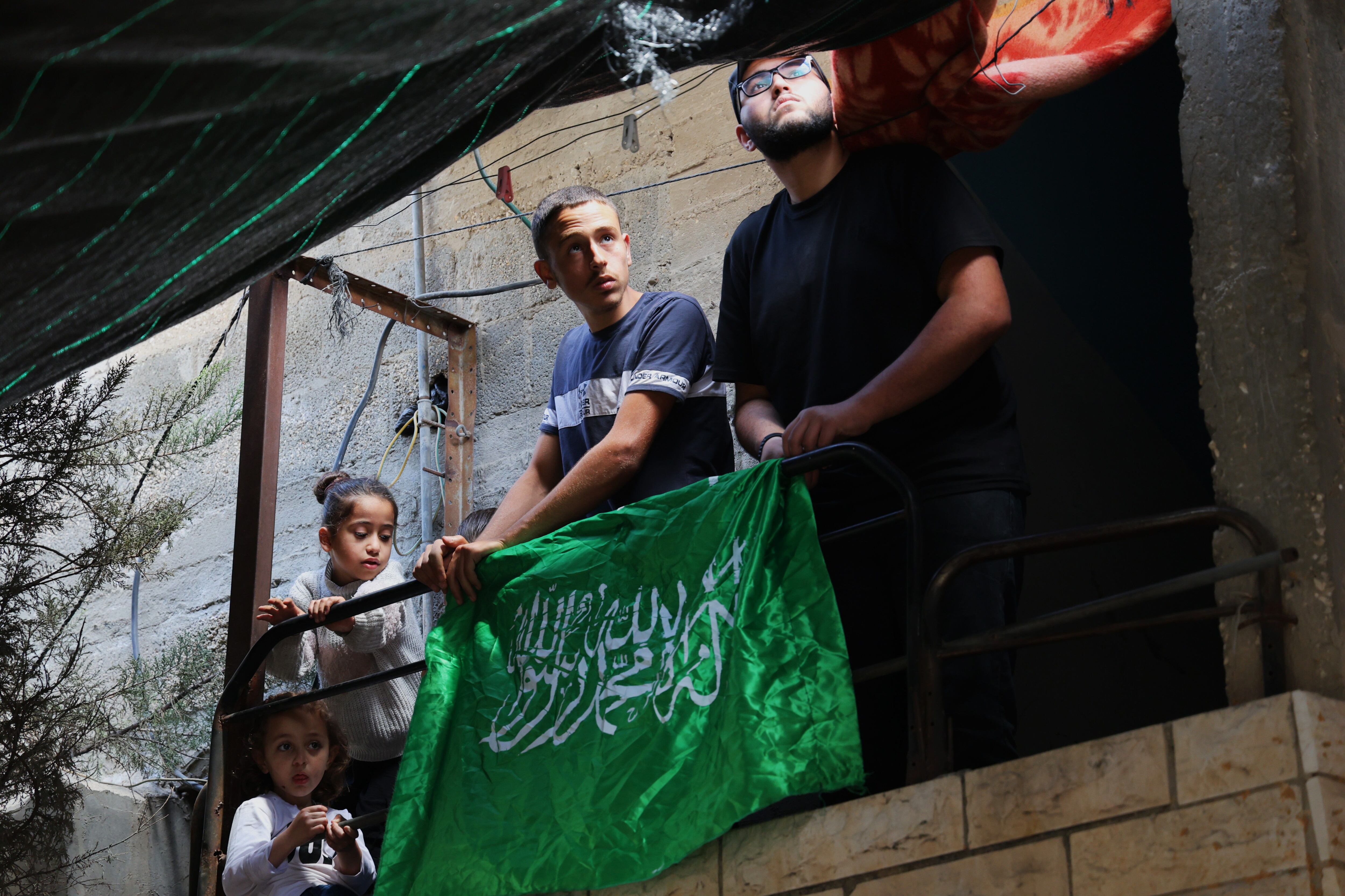 Unos palestinos colocan la bandera de Hamás en casa de una de las víctimas de la operación militar en Cisjordania, en el campo de refugiados de Nur Chams este domingo.