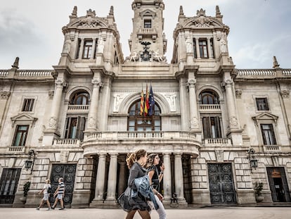 Viandantes ante la fachada del Ayuntamiento de Valencia, en abril de 2022.