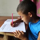 Un niño hondureño trabaja en un cuaderno escolar desde su casa, debido a que no puede ir a la escuela por la covid-19