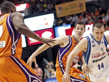 El base del Lagun Aro, Javier Salgado, trata de superar la defensa de los jugadores del Valencia Basket, el base San Miguel y el ala p&iacute;vot franc&eacute;s Pietrus.