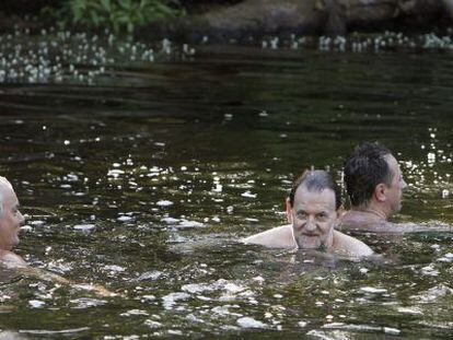 Mariano Rajoy (2d), durante sus vacaciones de verano de 2015, dándose un baño con unos amigos en Pontevedra