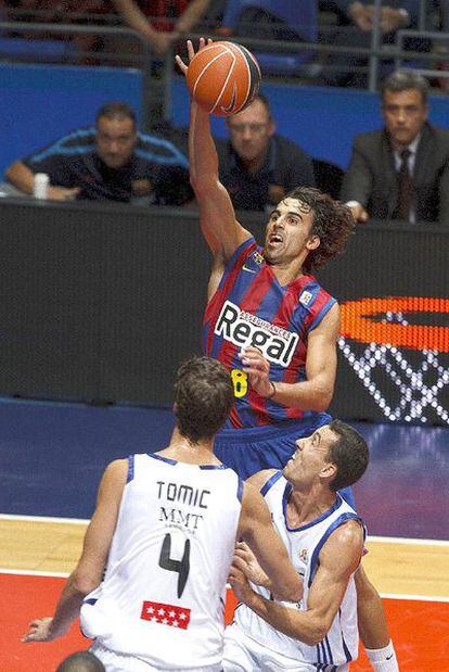 El base del Barcelona Víctor Sada entra a canasta superando a dos jugadores del Real Madrid durante la segunda semifinal de la Supercopa de baloncesto.