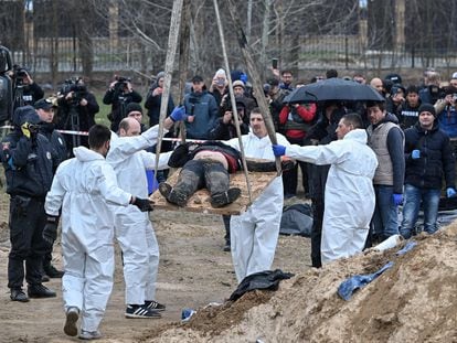 Investigadores forenses exhumaban un cadáver de una fosa común, el viernes en Bucha.