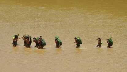Un grupo de indígenas en aislamiento cruza un río en departamento de Madre de Dios, en Perú. Si tuvieran una afección, habría de ser atendidos en la orilla.
  
 