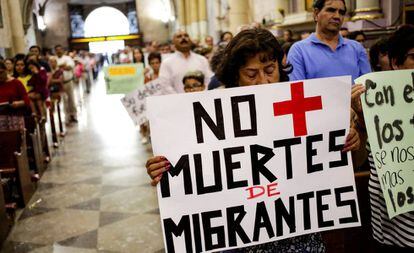 Un mujer carga un letrero durante una misa en honor de un migrante hondureño que fue asesinado por un oficial mexicano.