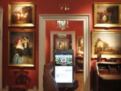 Un teléfono muestra el Twitter del Museo del Romanticismo, en una de sus salas.