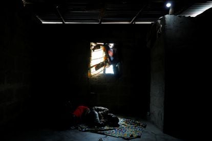 Una mujer llamada Recent Kodjo descansa en su habitación iluminada con una bombilla alimentada por la energía solar en la comunidad de Sagbo-Kodji, en Lagos, Nigeria 25 de abril de 2020.
