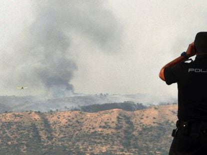 Un agente observa el incendio en el campo de tiro de la base de Cerro Muriano.