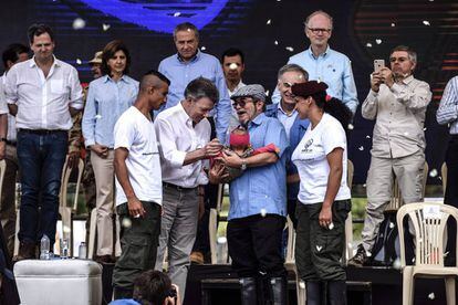 El líder rebelde de las FARC, Rodrigo Londono Echeverri, conocido como "Timochenko" (c) sostiene a un bebé, junto al presidente colombiano Juan Manuel Santos (2-i), el Representante Especial del Secretario General de la ONU para Colombia y Jefe de la Misión de las Naciones Unidas en Colombia, Jean Arnault (2-d) y dos miembros de las FARC, durante el último acto de abandono de armas y el fin de las FARC como grupo armado en la Zona de Estandarización Transitorio Mariana Paez, Buenavista, municipio de Mesetas, Colombia.