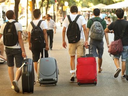 Un grupo de turistas camina con sus maletas por la Rambla de Cataluña, en Barcelona.