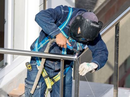 Un soldador, durante el montaje de una barandilla en la construcción de unas viviendas. EFE/Luis Tejido