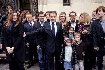 El presidente francés Nicolas Sarkozy (centro) al salir de votar hoy.