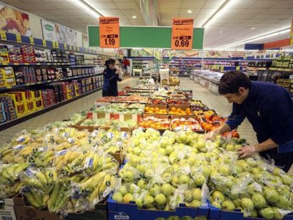 Dos empleados reponen la fruta en un supermercado de Madrid