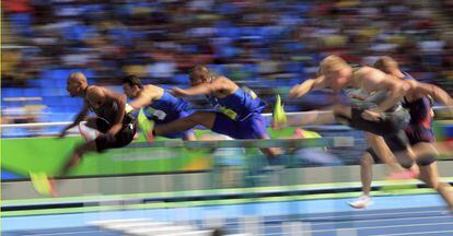 Atletas compiten en los 110 m obstáculos.
