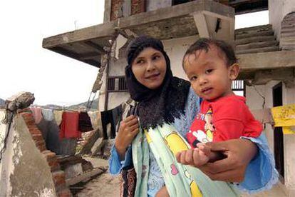 Marianna Hadin, con su hija, ante los restos de la que era su casa de Banda Aceh (Indonesia).